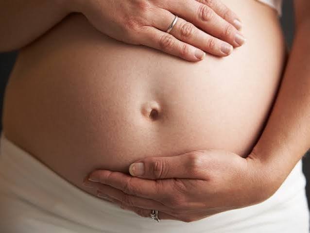Ventre d'une femme enceinte, mains posées dessus